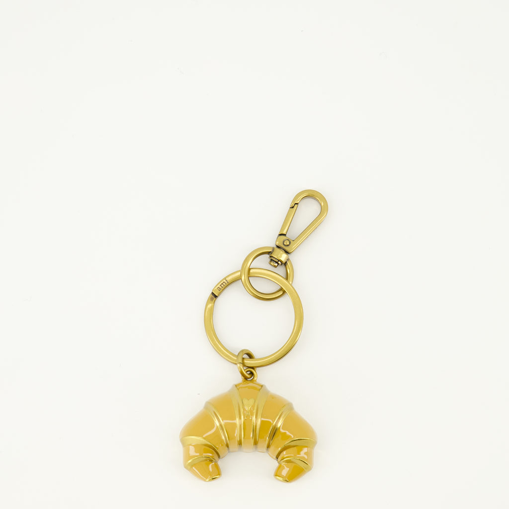 Imagem do porta-chaves em metal em forma de croissant da marca Ami PARIS para Unisex - Temporada Primavera-Verão 2026 - Vista Frontal