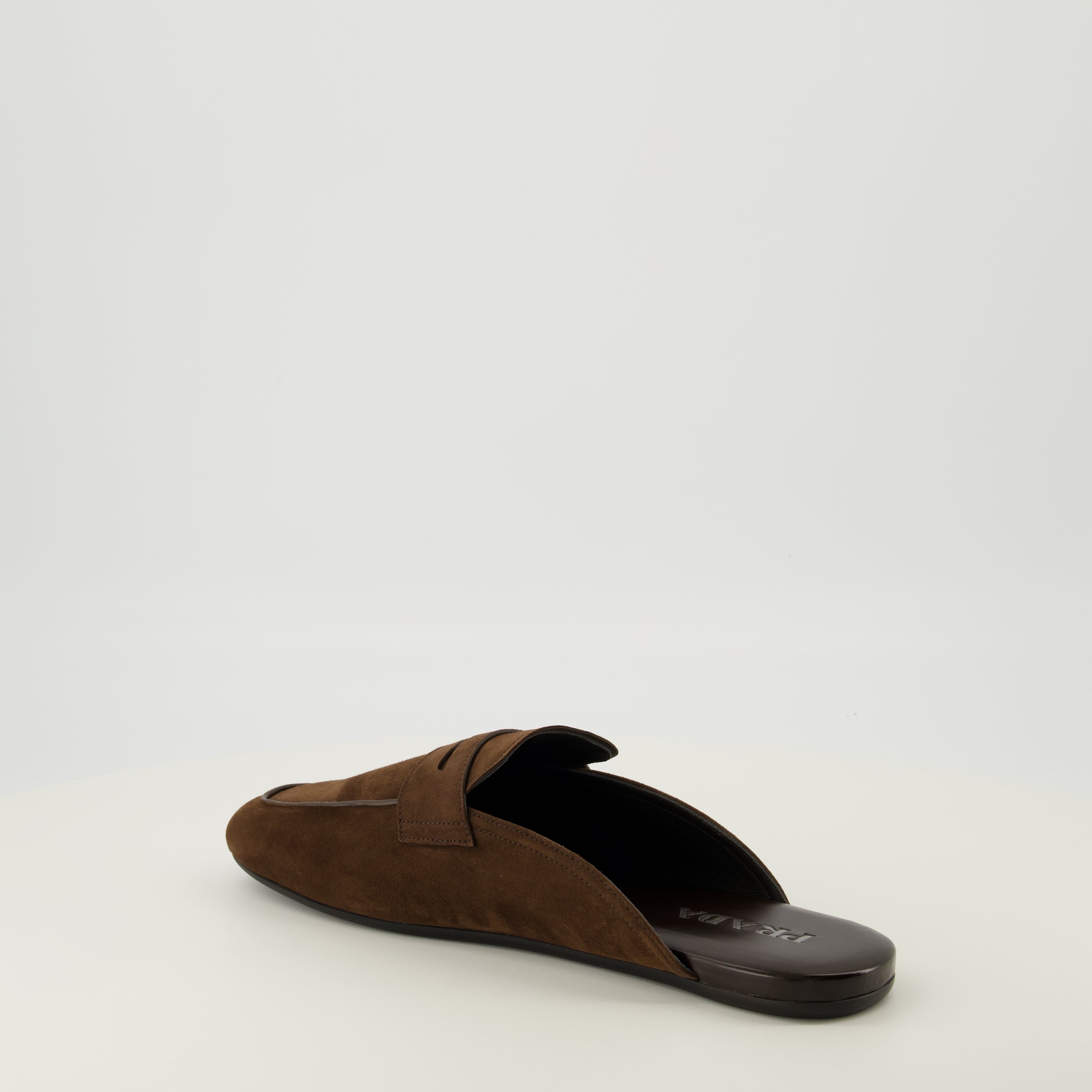 Image de l'article Mules mocassins en cuir suédé marron de la marque Prada pour Homme - Saison Printemps-Été 2026 - Vue trois quarts arrière droite