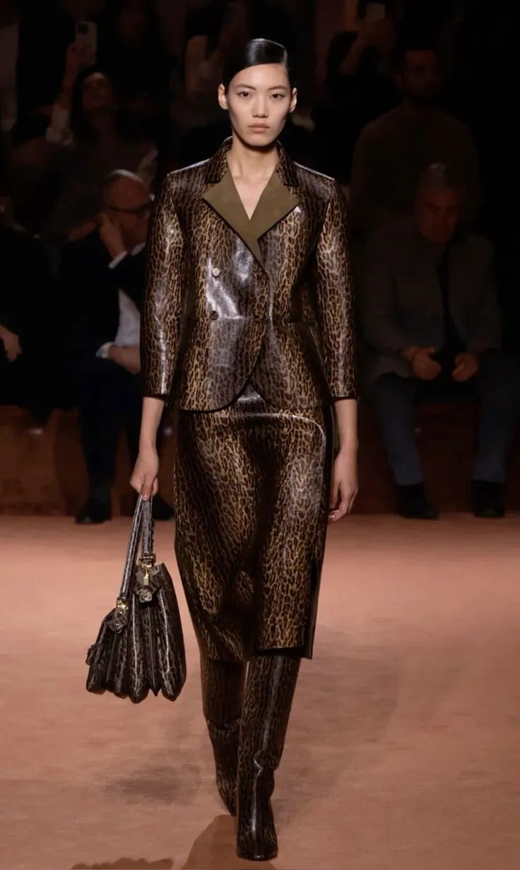 Défilé Fendi – mannequin portant un ensemble tailleur jupe et veste en cuir imprimé léopard avec sac assorti, look animalier sophistiqué automne-hiver.