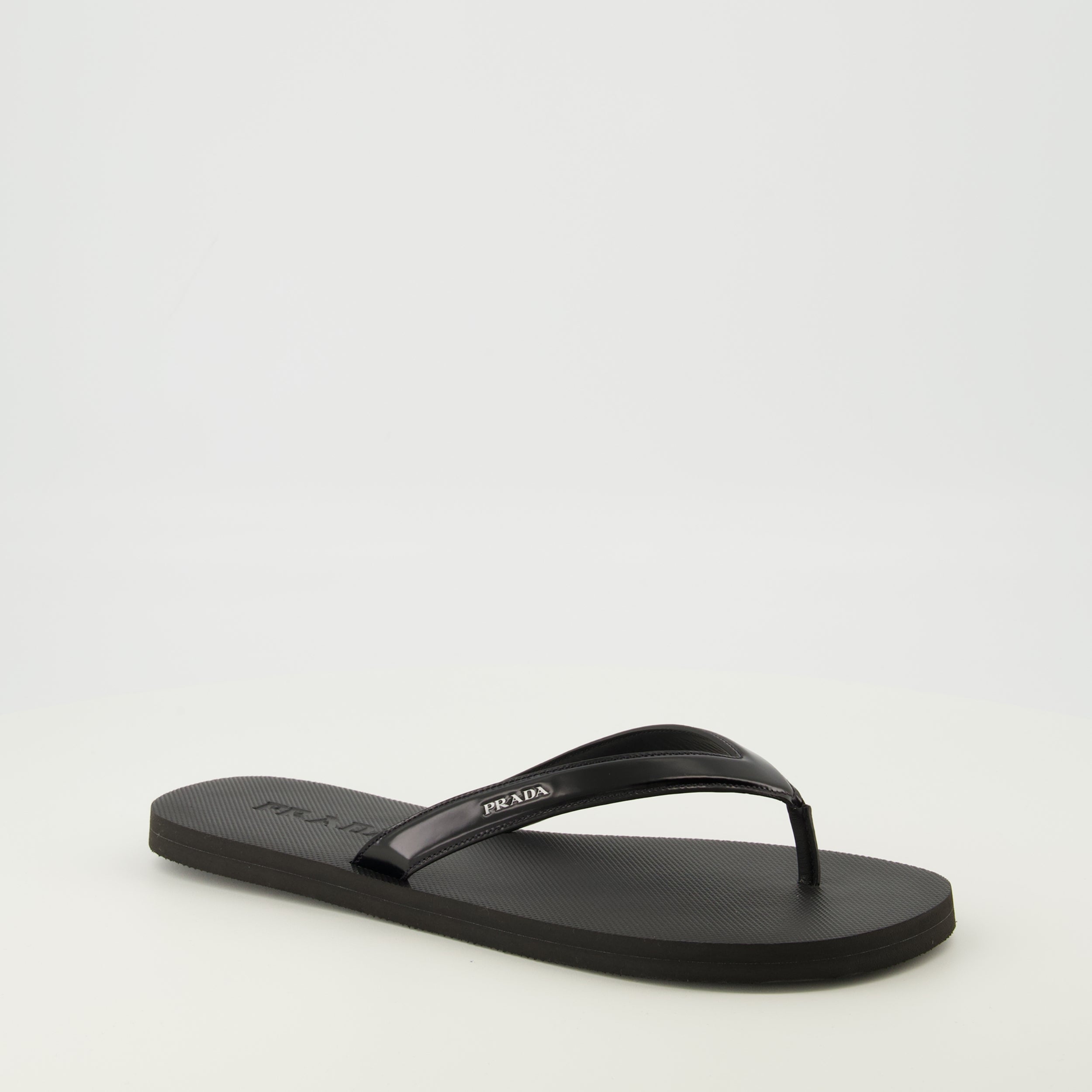 Image de l'article Tongs noires en cuir brossé de la marque Prada pour Homme - Saison Printemps-Été 2026 - Vue trois quarts avant droite