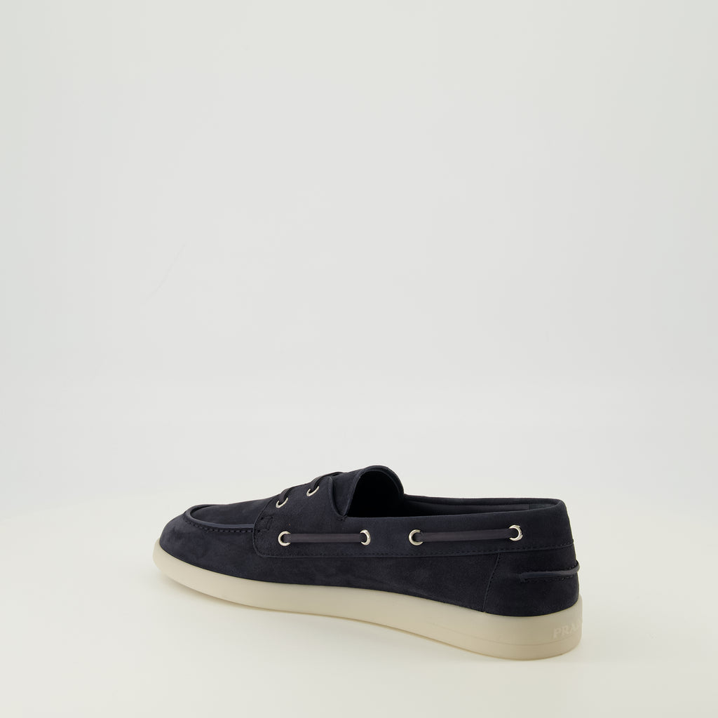Image of the navy blue suede loafers from the Prada brand for men - Spring-Summer 2026 season - Three-quarter back right view
