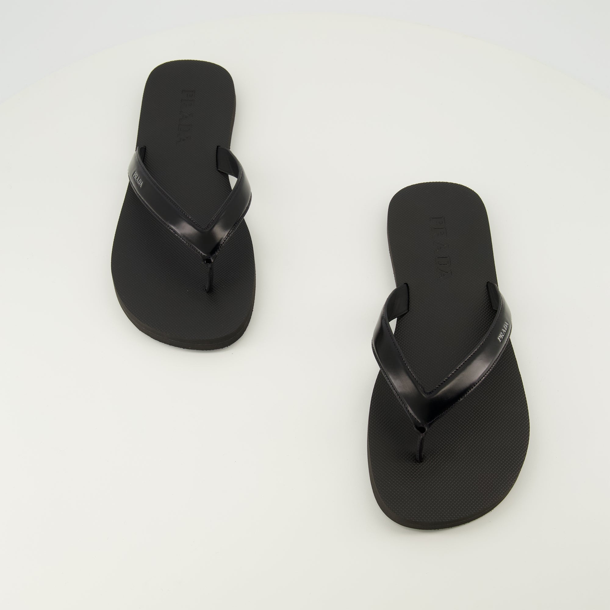 Image de l'article Tongs noires en cuir brossé de la marque Prada pour Homme - Saison Printemps-Été 2026 - Vue de dessus paire de chaussure